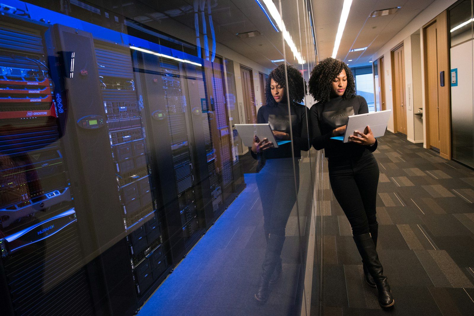 Server racks behind glass in a data center corridor